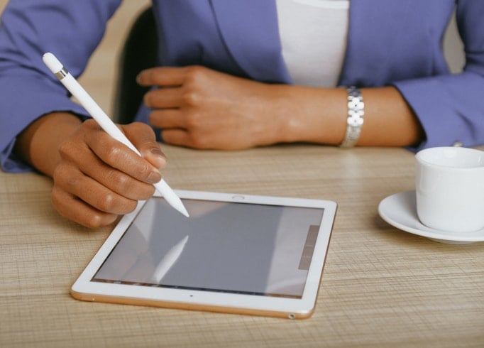 Person using a stylus on a tablet.